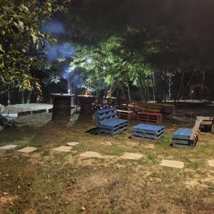 a group of benches sitting in a park at night at Casuța din livada in Albestii de Arges