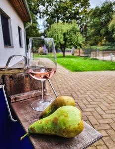 un bicchiere di vino e delle pere su un tavolo di Ferienwohnung zur Schlossruine a Boldekow