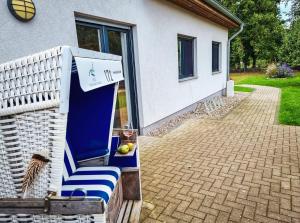 un patio con una sedia blu e bianca e una casa di Ferienwohnung zur Schlossruine a Boldekow