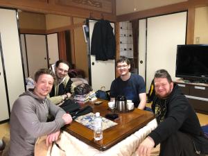 a group of men sitting around a table at 民宿とまとハウスTomato House in Funehiki
