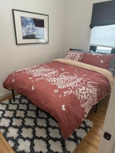 a bedroom with a bed with a red comforter at Modern Stay in Downtown Jersey City, Close to NYC! in Jersey City