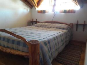a bedroom with a bed with a blue and white comforter at La Perlita de Trevelin in Trevelín