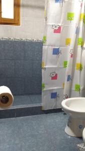 a bathroom with a shower curtain with animals on it at La Perlita de Trevelin in Trevelin