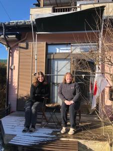 two women sitting on the front porch of a house at 民宿とまとハウスTomato House in Funehiki