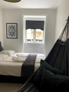 een bed met een hangmat in een slaapkamer met een raam bij Quiet room in lively area with helpful Host! in Kopenhagen