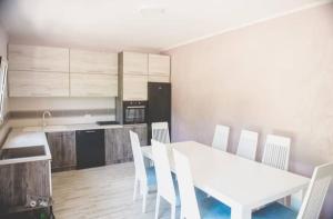 a kitchen and dining room with a white table and chairs at Javahome in Ocho Rios