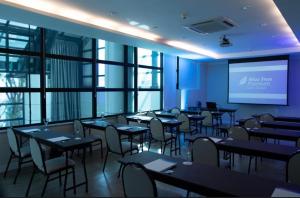 a dining room with tables and chairs and a screen at Hotel B Tree Jardins in Sao Paulo +42 photos