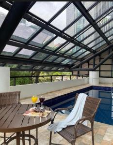 a patio with a table and chairs and a swimming pool at Hotel B Tree Jardins in Sao Paulo