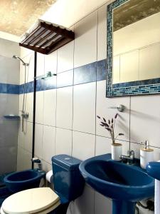 a bathroom with two blue sinks and a toilet at Complejo Aguazul in La Pedrera