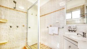 a bathroom with a shower and a sink at Sapphire City Motor Inn in Inverell +59 photos