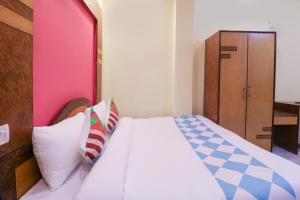 a bedroom with a bed with white sheets and pillows at Hotel O Home Cozy Studio Collage Square Hotel Maya International Near St. Thomas's Church in Kolkata