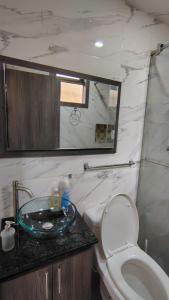 Un baño con lavabo, inodoro y espejo. en Apartmento Úbate, en Ubaté