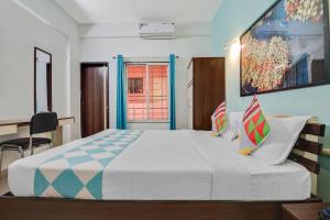 a bedroom with a large bed and a desk at Super Hotel O Pioneer in Pune