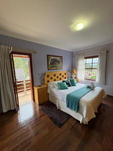 a bedroom with a large bed and a window at Pousada Atalaia Village in Campos do Jordão +95 photos