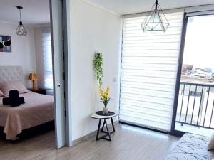 a bedroom with a bed and a table with yellow flowers at Sensacional Departamento Centro - Mar 1D 1B in Antofagasta