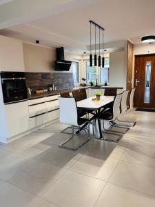 a kitchen and dining room with a table and chairs at Moana House LAURA in Trzęsacz