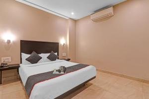 a hotel room with a large bed with a white bedspread at Super Townhouse Amaraa Hotel Near Phoenix Palassio in Lucknow