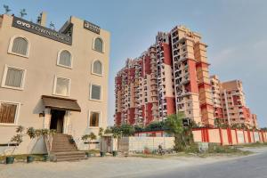 two tall apartment buildings are next to a street at Super Townhouse Amaraa Hotel Near Phoenix Palassio in Lucknow