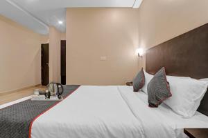 a hotel room with a large white bed with pillows at Super Townhouse Amaraa Hotel Near Phoenix Palassio in Lucknow +61 photos