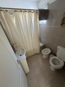 a bathroom with two toilets and a shower curtain at Croeso! in Puerto Madryn +17 photos
