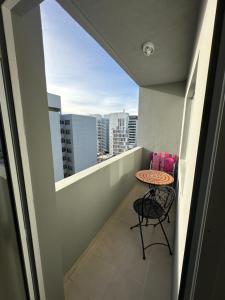 a balcony with a table and a view of a city at Croeso! in Puerto Madryn
