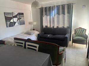 a bedroom with a bed and a couch and a chair at Croeso! in Puerto Madryn