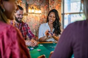 eine Gruppe von Leuten, die um einen Tisch herum sitzen und Poker spielen in der Unterkunft Hot Tub-Game Room-Nintendo Switch-BBQ in Big Bear City Airport