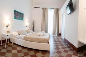 ein Schlafzimmer mit einem großen Bett und einem karierten Boden in der Unterkunft L'Opera Buffa in Palermo