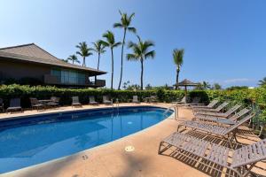 a swimming pool with lounge chairs and palm trees at Eldorado E204 · EL E204 Lanai with View Pool AC Beach Cabana Gym in Kaanapali