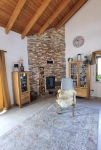 Una sala de estar con una chimenea de piedra y una silla. en Charming loft apartment with fireplace, en Scheuring