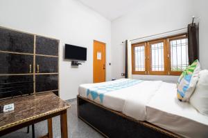 a bedroom with a bed and a tv in it at Hotel O Home Gautam Homestay in Dehradun