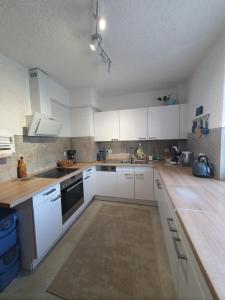 Una cocina con gabinetes blancos y encimera. en Charming loft apartment with fireplace, en Scheuring 3 fotos más