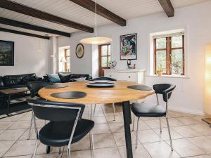 a kitchen and living room with a wooden table and chairs at 4 star holiday home in Asaa in Aså +26 photos