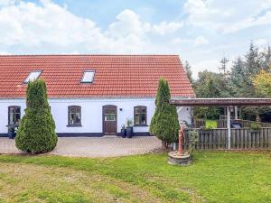 una casa blanca con techo rojo en 4 star holiday home in Asaa, en Aså