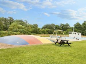 a park with a playground and a table and a swing at 4 person holiday home on a holiday park in Blåvand in Blåvand +46 photos