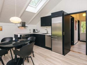 una cocina con una mesa y un refrigerador en 4 star holiday home in Silkeborg, en Abildskov