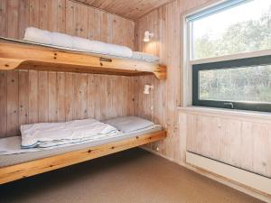 海尔斯4 person holiday home in Hals的有两张双层床和一扇窗户的房间