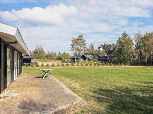 海尔斯4 person holiday home in Hals的建筑物旁边田野里的一张野餐桌