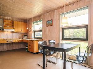 海尔斯4 person holiday home in Hals的房间里有一张桌子和几把椅子的厨房