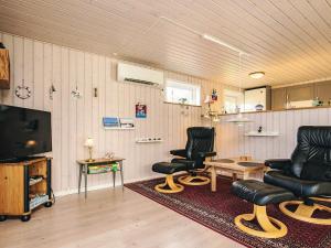a living room with two chairs and a television at 4 star holiday home in Hals in Hals