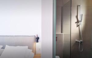 a shower in a bedroom with a bed and a glass door at Semeli in Kokkari