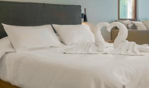 two swansrendered to look like they are kissing on a bed at Semeli in Kokkari