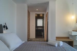 a bedroom with a bed with two towels on it at Semeli in Kokkari