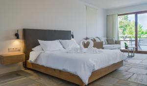 a bedroom with a large white bed and a couch at Semeli in Kokkari