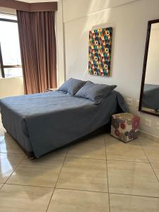 a bedroom with a bed with blue sheets and a television at Ap Aconchegante no Centro! in Campinas