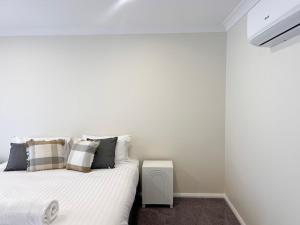 a small bedroom with a bed and a small table at Eliza's Escape 2 Wagga CBD in Wagga Wagga