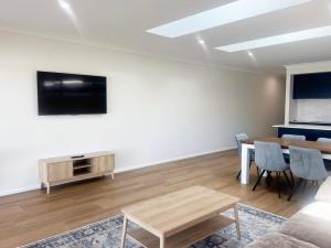 a living room with a table and a tv at Eliza's Escape 2 Wagga CBD in Wagga Wagga