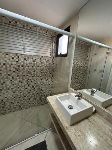 a bathroom with a sink and a mirror at Ap Aconchegante no Centro! in Campinas