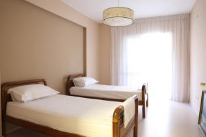 two beds in a room with a window at Casa Miel en el Botánico in Tirana