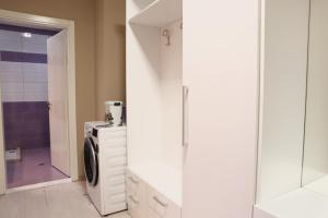 a bathroom with a washer and dryer next to a glass wall at Casa Miel en el Botánico in Tirana +30 photos